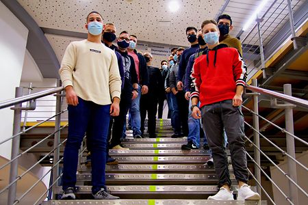 Warum sich ein Meisterkurs lohnt Angehende Industriemeister stehen auf der Treppe im Foyer der SIHK Akademie in Hagen.